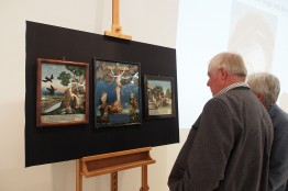 Zwei Besucher betrachten drei Hinterglasbilder