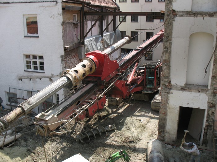 Eine riesige Baumaschine zwischen zwei Häuser auf der Museumsbaustelle