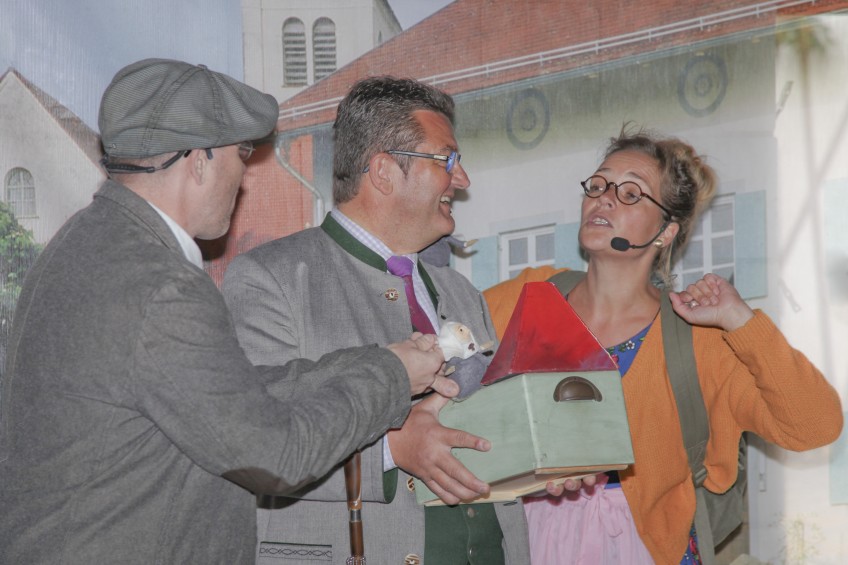 drei Personen spielen ein Theaterstück, rechts und links Mitglieder der Kulturwerkstatt, in der Mitte Herr Franz Pschierer