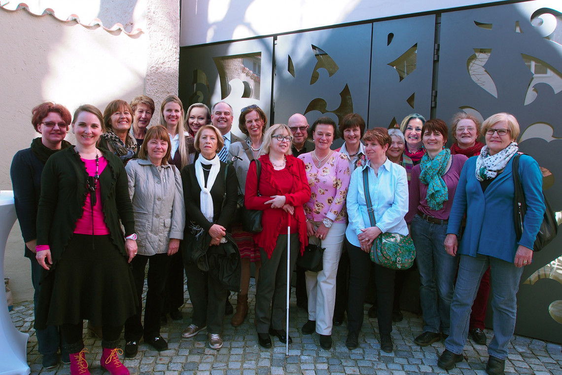 Gruppenfoto mit 18 Frauen und 2 Herren im Museumshof vor dem Ornament