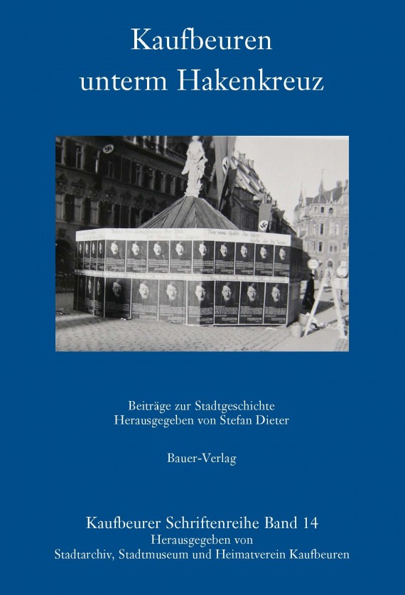 Blaues Buch mit dem Titel: &quot;Kaufbeuren unterm Hakenkreuz&quot;. Auf dem Cover ist ein Bild des Neptunbrunnens zu sehen, der von Hitler-Plakaten umgeben ist.