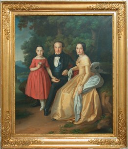 Gemälde der Familie Schrader: Ein Mann in schwarzem Anzug, seine Frau in gelbem Ballkleid und weißem Tuch und ihre Tochter in rotem Kleid sind vor einem Wald und den Bergen abgebildet.