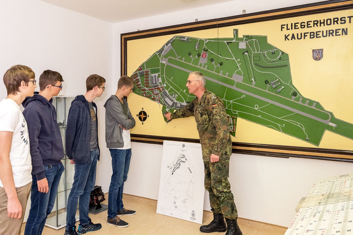 Matthias Tietje zeigt vier Schülern eine Karte des Fliegerhorstes Kaufbeuren