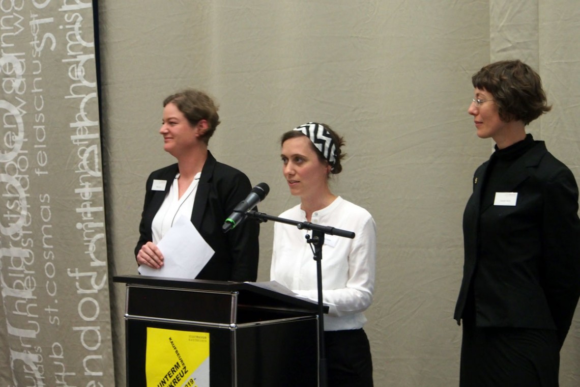 drei Frauen stehen hinter einem Rednerpult