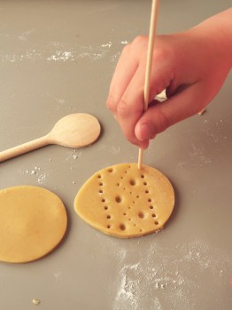 Die eierförmig ausgestochenen Kekse werden mit einem Schaschlikspieß mit Mustern eingedrückt