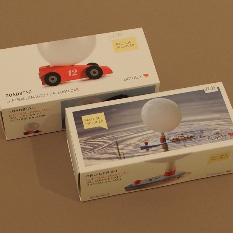 oben die Verpackung eines Luftballonautos, darunter die Verpackung eines Luftballonbootes