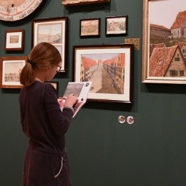Ein Mädchen mit einem Mitmachheft löst ein Rätsel vor der Bildergalerie in der Sonderausstellung