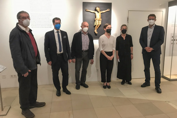 sechs Personen stehend vor dem Christkönig in der Dauerausstellung, alle mit FFP2-Maske