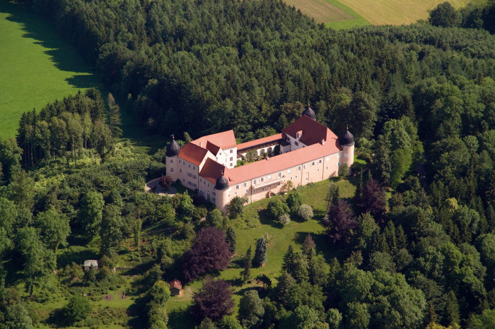 Luftaufnahme von Schloss Kronburg umgeben von Wald