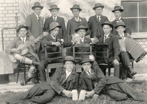 Gruppe junger Männer mit Instrumenten und Bierkrügen